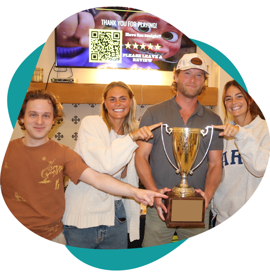 Winning team pointing at the trophy after a Trivia Nation game show