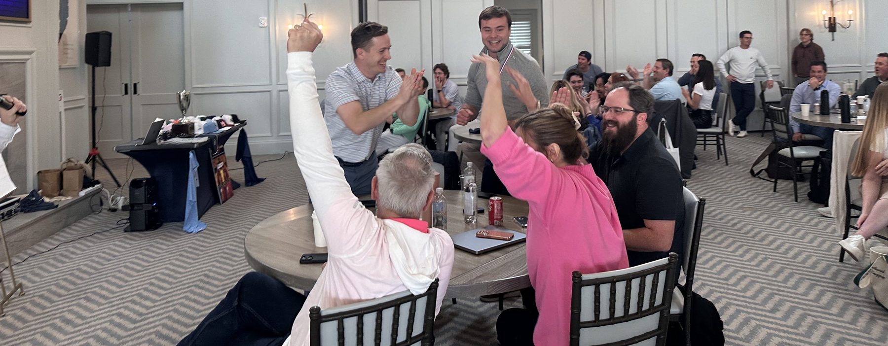 Neighbors cheering a correct answer during a community game night